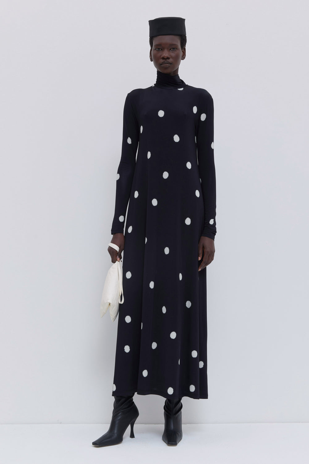 Elegant black jersey maxi dress with oversized white polka dots, fitted turtleneck and relaxed A-line shape by Christian Wijnants.