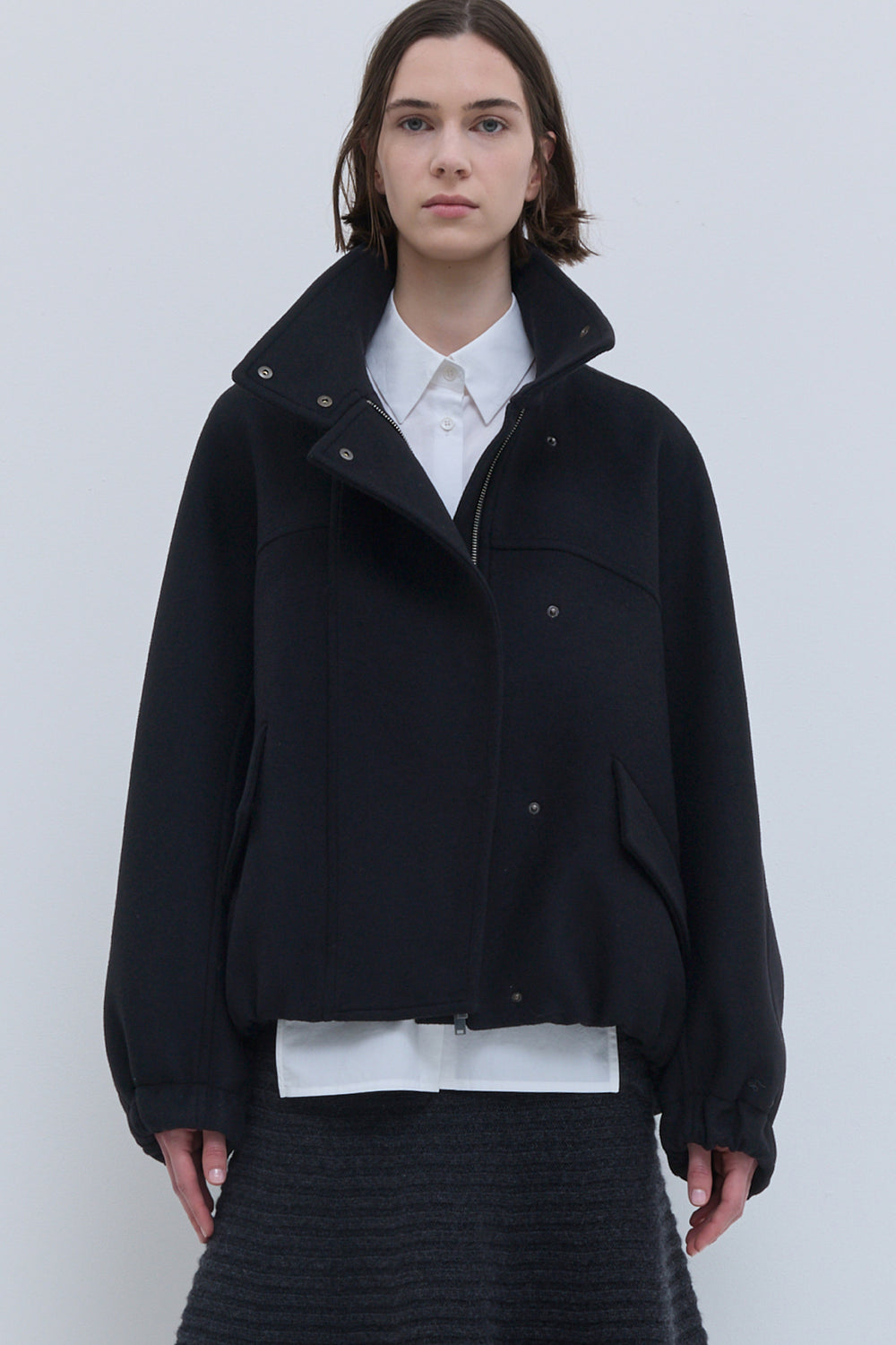 Front view of Christian Wijnants Japuto black wool bomber jacket with high collar and storm flap