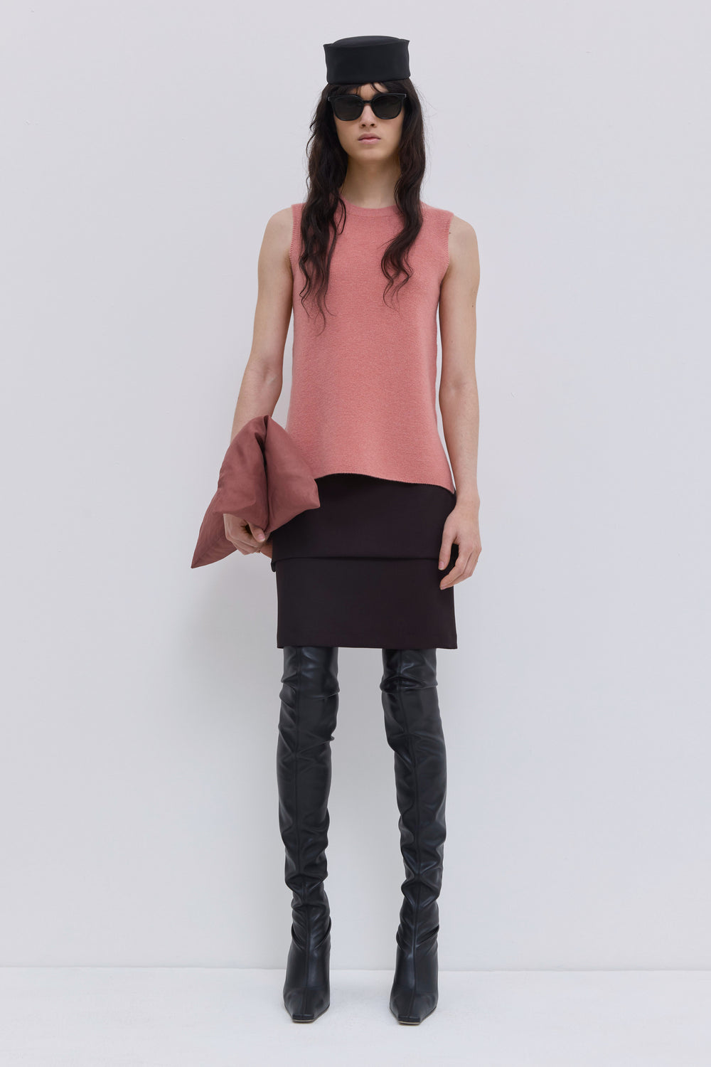Coral sleeveless wholegarment knit top with round neckline and side slits.