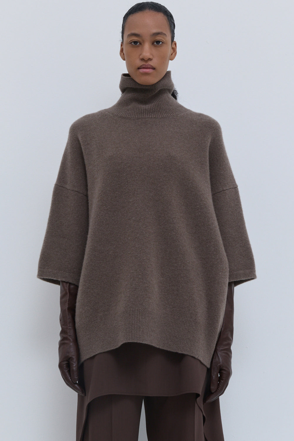 Oversized brown melange turtleneck sweater styled with wide-leg brown trousers