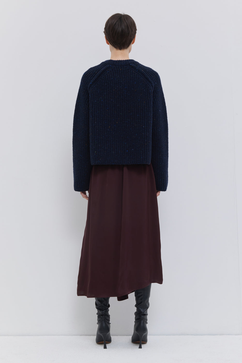 Side view of the Sedona asymmetric skirt in plum with elegant draped front panel.
