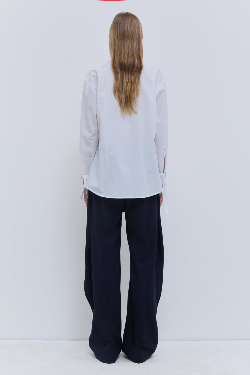 Christian Wijnants Talina white V-neck shirt with long sleeves and cuff detail.