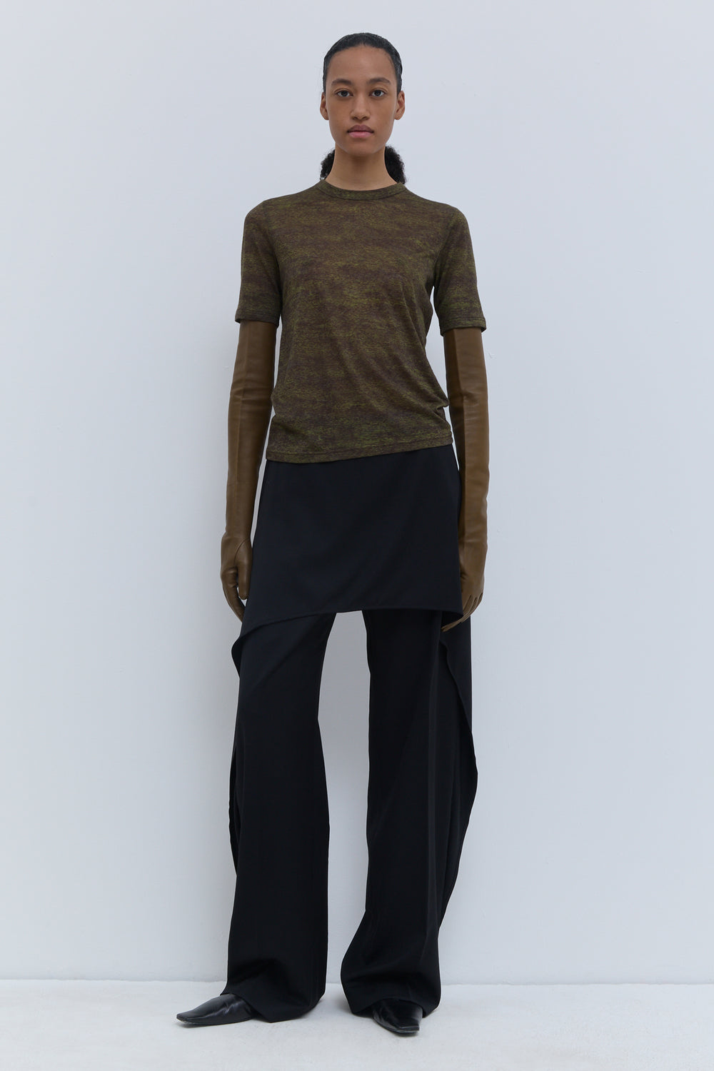 Luxury wool crewneck T-shirt in a rich dark green melange, styled with wide-leg trousers.