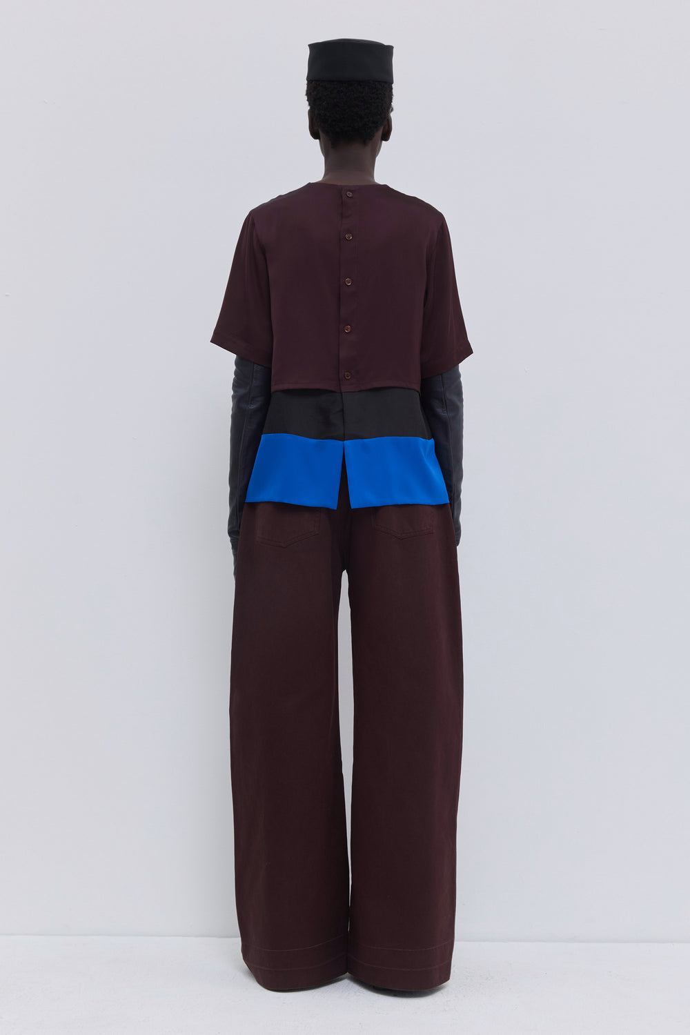 Back view of the Christian Wijnants Tuno silk top with button closure, back slit and plum cobalt patchwork design.
